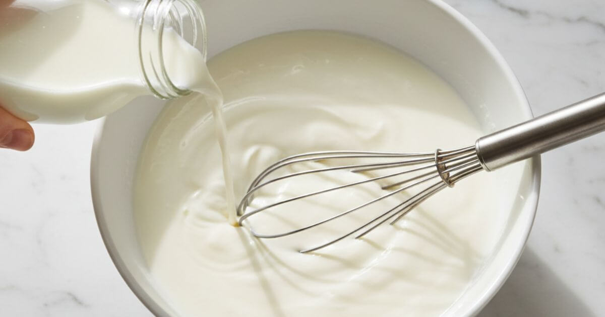 Making lassi from scratch: whisking yogurt with sugar for lassi